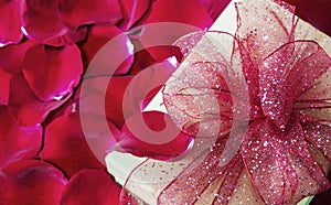 Gift box on red rose petals background
