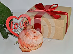 Gift box, rose flower and decorative heart on white background