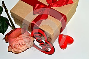 Gift box, rose flower and decorative heart on white background