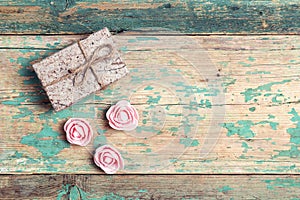 Gift box with roses and copy space on old wooden turquoise background