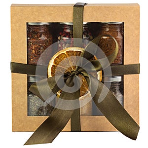 Gift box with a set of different spices in glass jars isolated on a white background