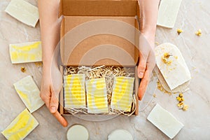 Gift box with set of natural soap in female hands. DIY soaps kit. Many various homemade bar soaps. Hygiene toiletries Flat lay