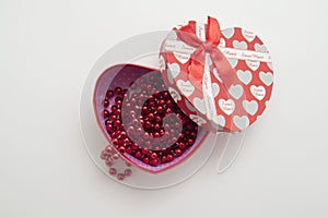 gift box in the shape of a heart with red beads on a white background. Valentine's Day. mothers Day. women's Day