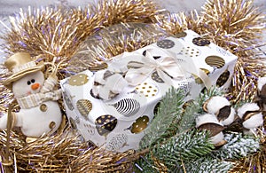 gift box, snowman, fir branch, cotton branch, among Golden tinsel, Christmas gift