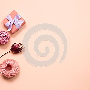 Gift box and string with dry tulip flower on pink background