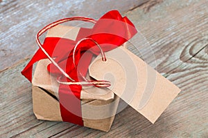 Gift box with tag with empty space for a text on wooden backg