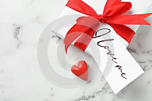 Gift box with tag I Love Me on white marble table, flat lay. Space for text