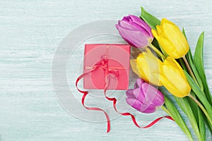 Gift box and tulip flowers on rustic table for March 8, International Womens day, Birthday or Mothers day