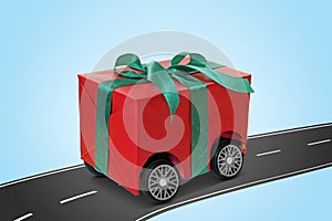 Gift box with wheels riding on asphalt road against light blue background. Delivery service