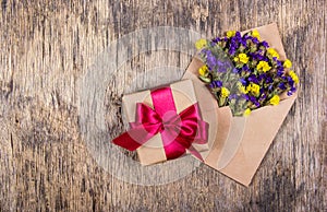 Gift box and wild flowers in an envelope. Holidays and gifts. Copy space