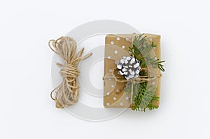 Gift box wrapped in brown recycled paper and tied sack rope top view isolated on white background, clipping path