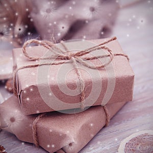 Gift box wrapped in brown recycled paper and tied sack rope top view on white background, snowflakes. instagram.