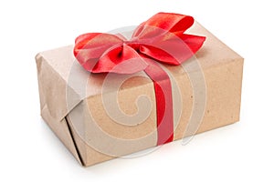 Gift box wrapped in kraft paper with red ribbon bow, isolated on white background