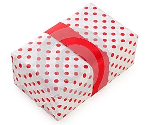 Gift box wrapped in white paper with red dots and bright red ribbon. Isolated on a white background, top view