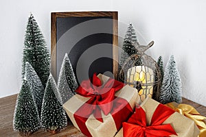 Gift boxes and Blank Blackboard wooden easel with Christmas tree and LED candle light