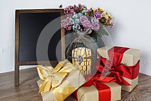 Gift boxes and Blank Blackboard wooden easel with flower and LED candle light decoration