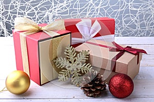 Gift boxes with bow and christmas balls on wood background. Decoration