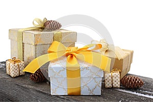 Gift boxes with bows and fir cones on an wooden background i