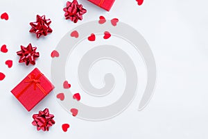 Gift boxes, bows and red hearts on a white background.