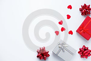 Gift boxes, bows and red hearts on a white background.