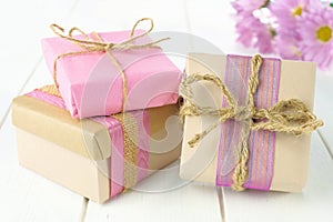 Gift boxes with brown and pink wrapping on white wood