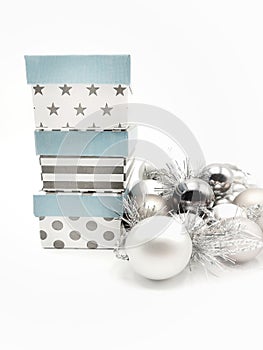 Gift boxes and Christmas decorations with silvered ribbons in white background