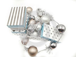 Gift boxes and Christmas decorations with silvered ribbons in white background