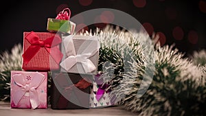 Gift boxes and christmas tree on table with lights in background