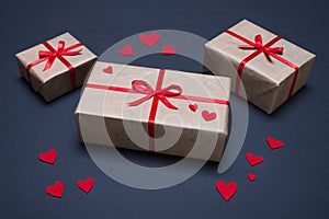 Gift boxes decorated with red ribbons with bows lie on a black background