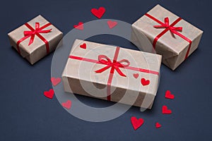 Gift boxes decorated with red ribbons with bows lie on a black background