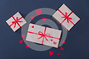 Gift boxes decorated with red ribbons with bows lie on a black background