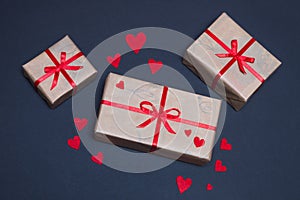 Gift boxes decorated with red ribbons with bows lie on a black background