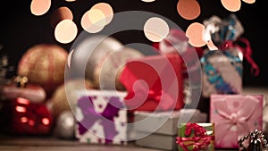 Gift boxes and decorations on table with lights in background