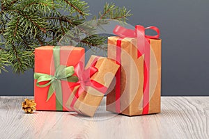 Gift boxes and fir tree branch on gray background