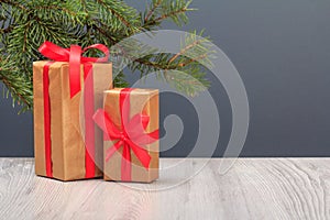 Gift boxes and fir tree branch on wooden boards and gray background