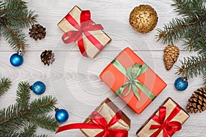 Gift boxes, fir tree branches with cones and christmas toys on boards