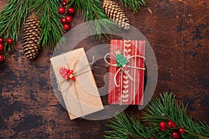 Gift boxes and fir tree branches on wooden background. Christmas greeting card. Top view. Copy space