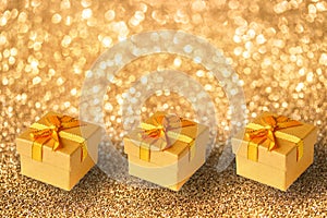 Gift boxes on a gold shiny background. Holiday concept