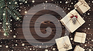Gift boxes over dark wooden background. Top view. Fir tree, space for text. Effect snowflakes
