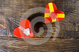 Gift boxes papier mache in the form of red hearts tied with satin ribbons and gifts Packed by craft paper on the wooden table.