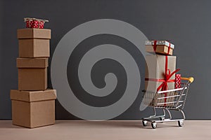 Gift boxes piles and shopping cart on dark background