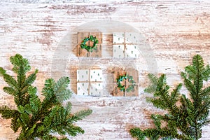Gift boxes and pine branches on a white wooden background