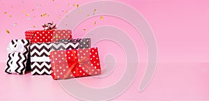 Gift boxes with ribbon bow and konfetti on pink background. Merry Christmas, New year and sale event concept photo