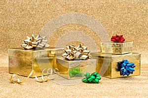 Gift boxes with ribbon bow over golden background