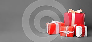 Gift boxes with ribbons and space for text on grey background. Banner design