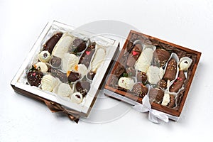 Gift boxes with ripe fruits covered the white and dark chocolate