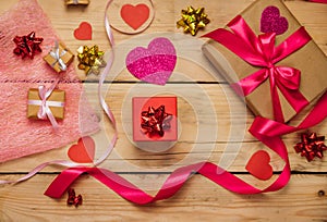 Gift boxes with satin ribbons on a wooden background. The concept of Valentine`s Day, Mother`s Day and Birthday