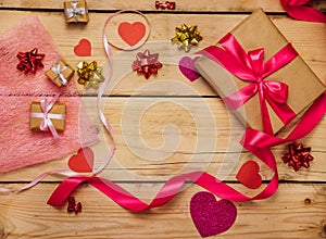 Gift boxes with satin ribbons on a wooden background. The concept of Valentine`s Day, Mother`s Day and Birthday