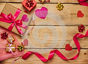 Gift boxes with satin ribbons on a wooden background. The concept of Valentine`s Day, Mother`s Day and Birthday