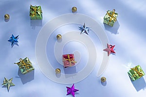Gift boxes with star and Golden Christmas baubles decoration on a white or snow background. sunlight rays, Top view